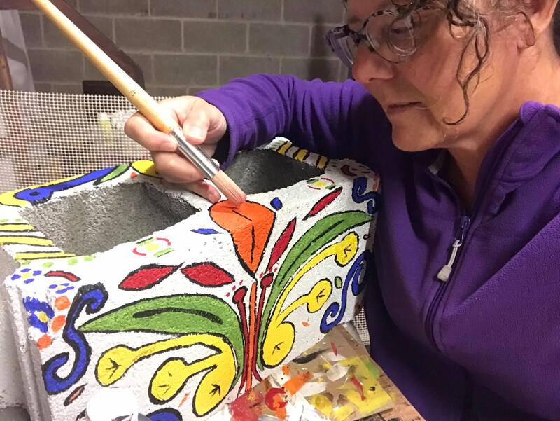 Hand-painting cinder blocks for custom garden makeover by Crows Nest Arts